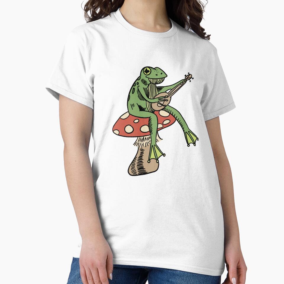 frog sitting on a mushroom playing guitar by moonna designs